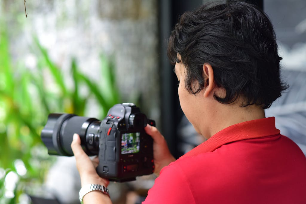 photo par sóc năng Động A photographer with a DSLR camera capturing nature in an outdoor setting.